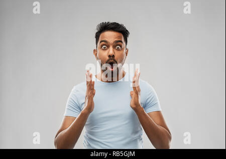 scared man in t-shirt over grey background Stock Photo