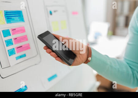 ui designer or developer hand holding smartphone Stock Photo