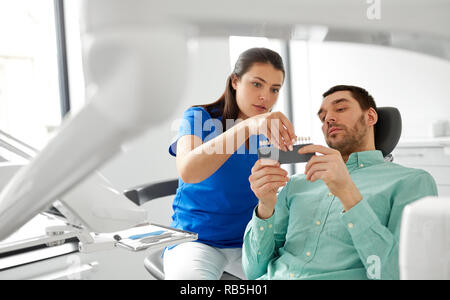 dentist choosing tooth color for patient at clinic Stock Photo