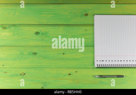 Notepad and pen on a green wooden table Stock Photo