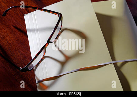 yellow file folder and reading glasses on office desk Stock Photo