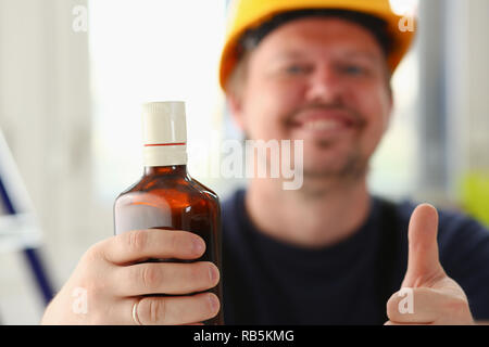 Arm of drunken worker in yellow helmet Stock Photo