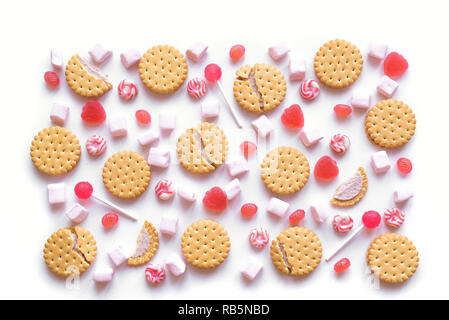Pink candies, marshmallows and cookies pattern on white background. Various pink sweets for Valentine Day as backdrop, top view. Stock Photo