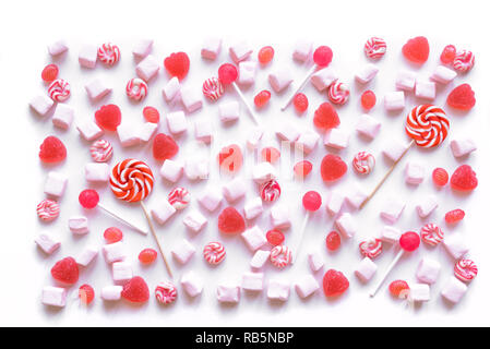 Pink candies and marshmallows pattern on white background. Various pink sweets for Valentine Day as backdrop, top view. Stock Photo