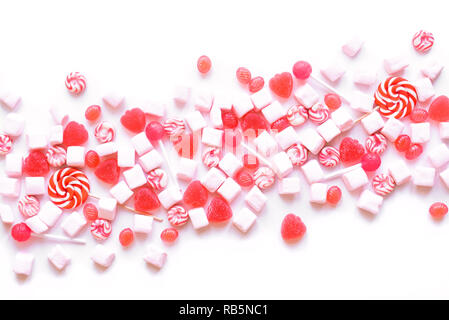 Pink candies and marshmallows pattern on white background. Various pink sweets for Valentine Day as backdrop, top view. Stock Photo