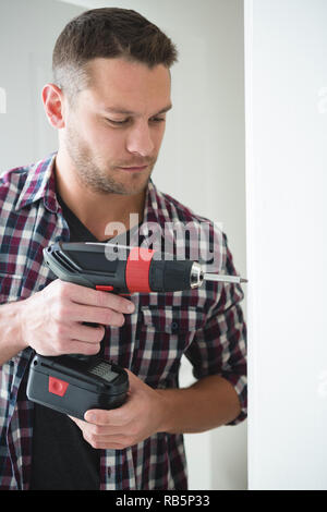 Male carpenter using drill machine Stock Photo