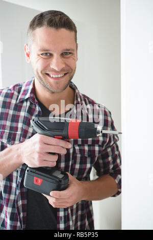 Male carpenter using drill machine Stock Photo