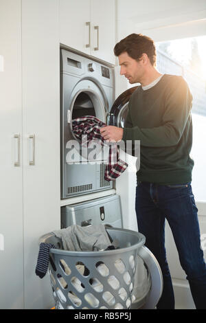 https://l450v.alamy.com/450v/rb5p5j/man-putting-clothes-in-washing-machine-rb5p5j.jpg