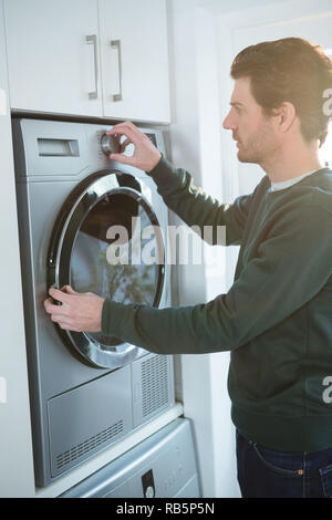 Man operating washing machine Stock Photo