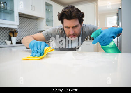 Man cleaning kitchen worktop at home