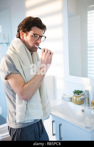 Man brushing his teeth in bathroom Stock Photo