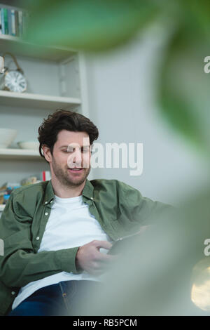 Man using digital tablet in living room Stock Photo