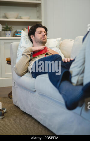 Man sleeping on sofa in living room Stock Photo