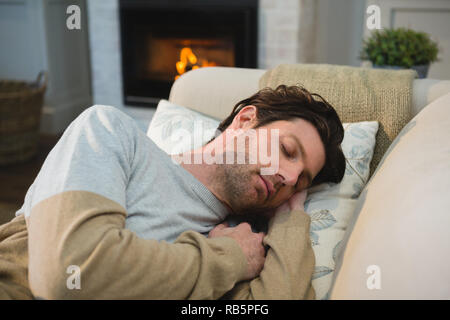 Man sleeping on sofa in living room Stock Photo