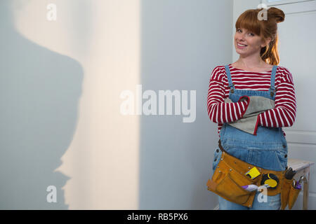 Female carpenter standing with arms crossed at home Stock Photo
