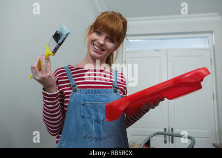 Female painter holding a paintbrush at home Stock Photo