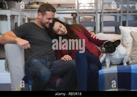Couple relaxing with their pet dog in living room Stock Photo