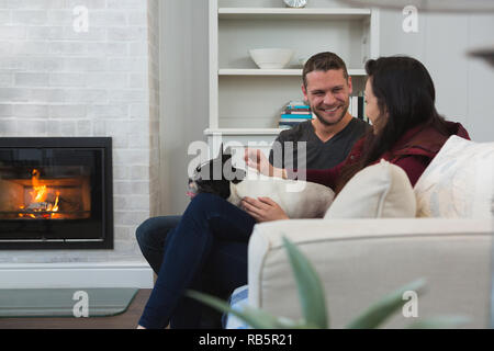 Couple relaxing with their pet dog in living room Stock Photo