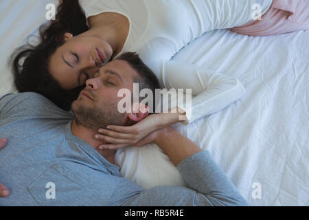 Couple sleeping on bed in bedroom Stock Photo