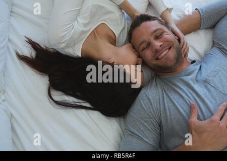 Couple lying on bed in bedroom Stock Photo
