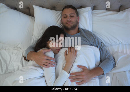 Couple sleeping on bed in bedroom Stock Photo