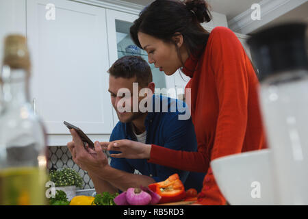 Couple using digital tablet in kitchen Stock Photo