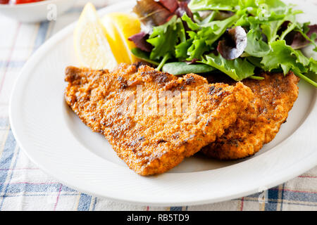 Homemade breaded pork schnitzel with some green salad Stock Photo