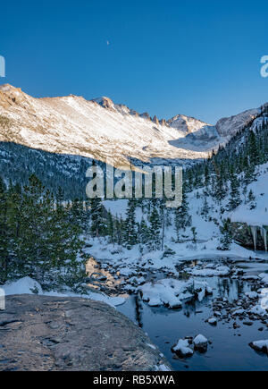 Hiking trail to a frozen lake beneath Spearhead in Rocky Mountain National Park Stock Photo