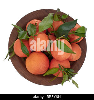 Oranges. Several ruits with leaves on plate, top view, isolated on white. Stock Photo