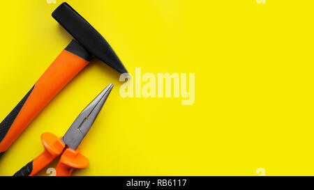 Tools worker, hammer, pliers on bright yellow background, top view Stock Photo