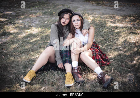 Two girls spend time together outdoors. The concept of difficult teenagers, bad students. Teenage problems. Stock Photo