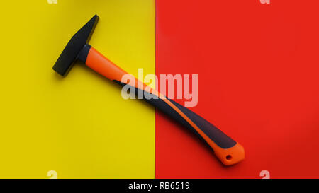 Hammer tool isolated on yellow and red background with copy space Stock Photo