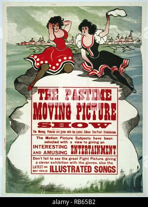 The Pastime moving picture show 1913. Advertising poster for Thomas Edison's kinetoscopic films shows in the background, a boardwalk visible on the horizon; in the foreground, two women are perched on a rock in the ocean, they are wearing turn-of-the-century bathing costumes; one of the women is waving a white handkerchief. Stock Photo
