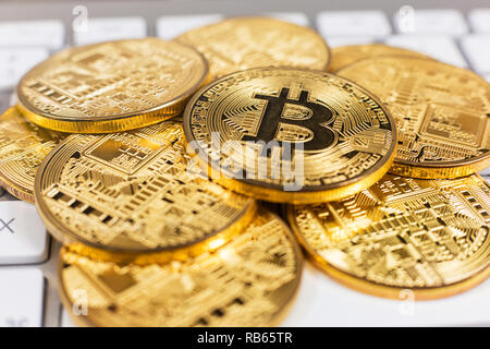 Stack of bitcoins lying on computer keyboard Stock Photo