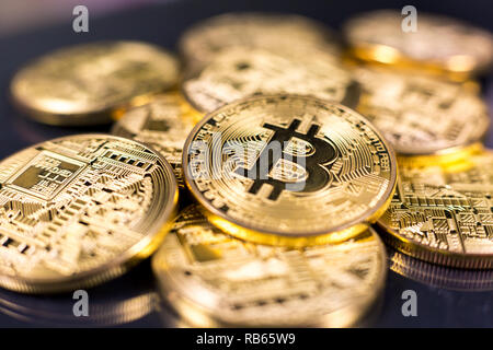 Stack of bitcoins lying on shiny dark surface Stock Photo