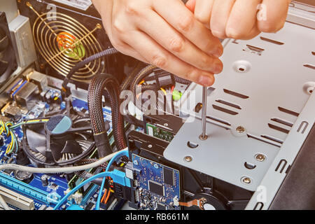 Hardware installation and upgrades of the computer system unit with help of screwdriver. Stock Photo