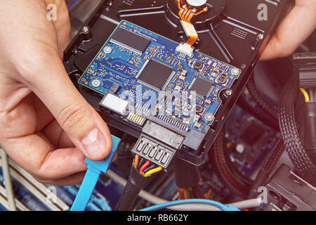 Connecting the HDD to the desktop PC with help of SATA cable blue. Stock Photo