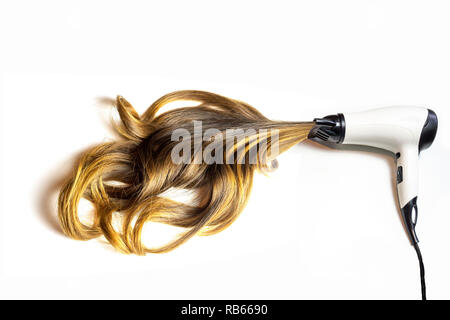 hair dryer blowing brown balayage curvy hair on isolated white background - styling concept Stock Photo