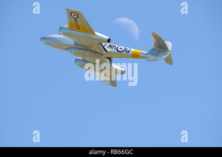 Gloster Meteor fighter jet plane flying past the moon in blue sky. Early jet fighter, Meteor T7 WA591 restored. RAF first jet Stock Photo