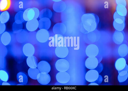 Blurred bokeh colorful lights lanterns, holiday new year lighting on black background Christmas winter glitter shiny light bokeh in rainbow colors. Ho Stock Photo