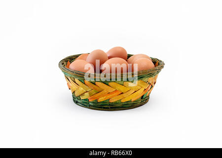Large brown free-range eggs in a coloured rustic wicker basket Stock Photo