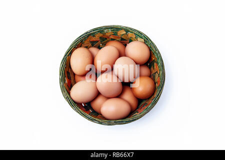 Large brown free-range eggs in a coloured rustic wicker basket Stock Photo