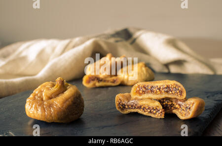Dried figs with sliced one on dark rustic background Stock Photo
