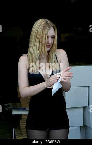 Blonde woman wiping some dirt off of her hand Stock Photo
