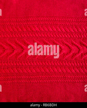 Red Knitted pattern wool sweater texture close up. Handmade red knitting wool texture background Stock Photo
