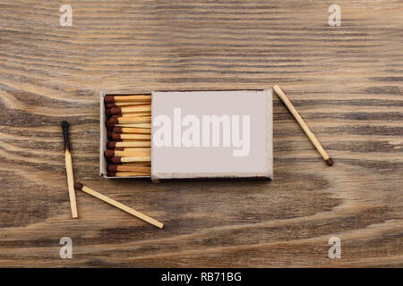 Matches with brown gray in a matchbox on a wooden table. Rustic style Stock Photo