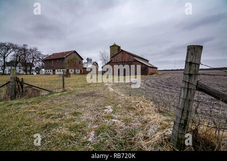 Fence post and barbed wire at the entrance to a rural midwest farm on a cold winters day. Plano, Illinois. Stock Photo