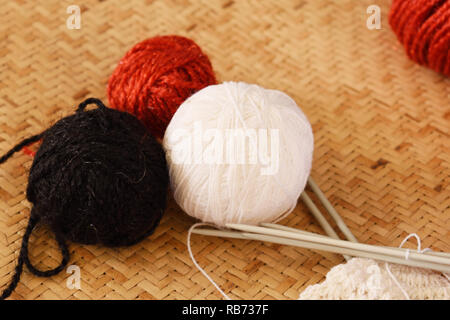Beautiful Black,red and white yarn ball with knitting stick isolated in brown background Stock Photo
