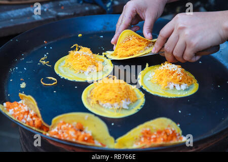 Delicious Thai street dessert, Kanom Buang, Thai Crispy Pancake or Thai Crepe, with varieties of fillings such as sweet white custard cream and golden Stock Photo