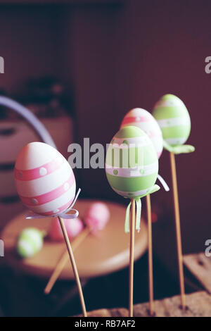 A beautiful close-up of 3 easter eggs on sticks over tables with an amazing depth of field as background Stock Photo